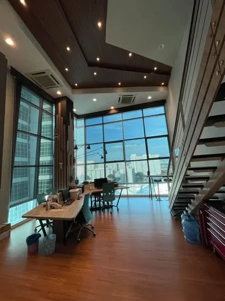 Room features: large floor-to-ceiling windows, wooden ceiling with recessed lighting, wood paneling on walls, laminate flooring, open space layout, modern office furniture, multiple workstations, staircase with wooden steps, city view, air conditioning units; style: modern; view: city.