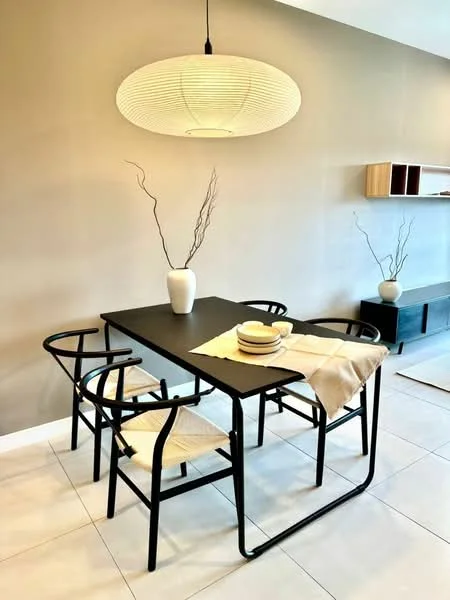 Dining features: black dining table, 4 dining chairs with woven seats, large round pendant light, decorative vase on table, table runner, plates and bowls on table, light beige wall, white tiled flooring; style: modern.