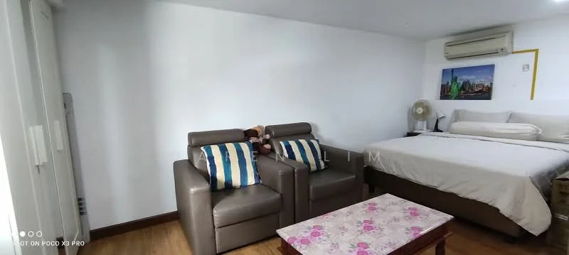 Room features: queen-size bed, upholstered headboard, 2-seater leather sofa in brown, striped throw pillows, wooden coffee table with floral pattern, wall-mounted air conditioning unit, wooden flooring, framed artwork on wall, table fan, nightstand; style: modern.