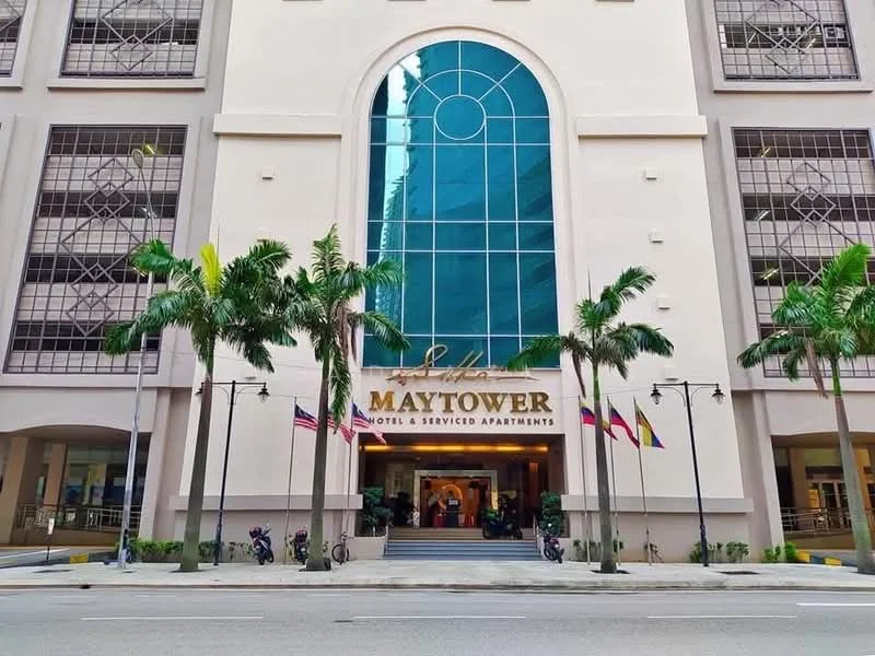 Exterior type: serviced apartment; features: glass curtain wall, white painted facade, double-volume main lobby, palm trees in front, entrance with steps, flags displayed, street view, surrounded by urban environment; style: modern.