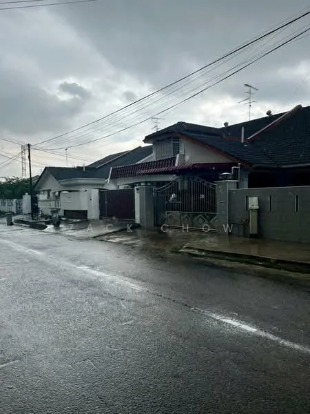 Exterior type: semi-detached house; features: grey painted facade, pitched tile roof, gated entrance, front yard with low wall, driveway, visible utility meters, street view with power lines, surrounded by residential area; style: modern.