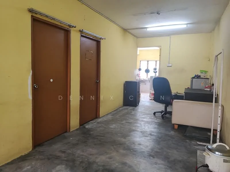 Room features: yellow painted walls, concrete flooring, two wooden doors, office desk, office chair, sofa, overhead fluorescent lighting; style: minimalist.