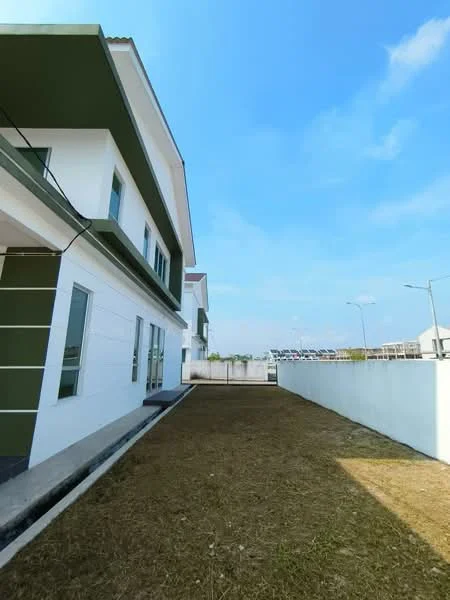 Exterior type: linked terrace house; features: white painted facade, green accent wall, two-storey building, manicured lawn, concrete pathway, side yard, clear blue sky, street lighting, adjacent parking area; style: modern.
