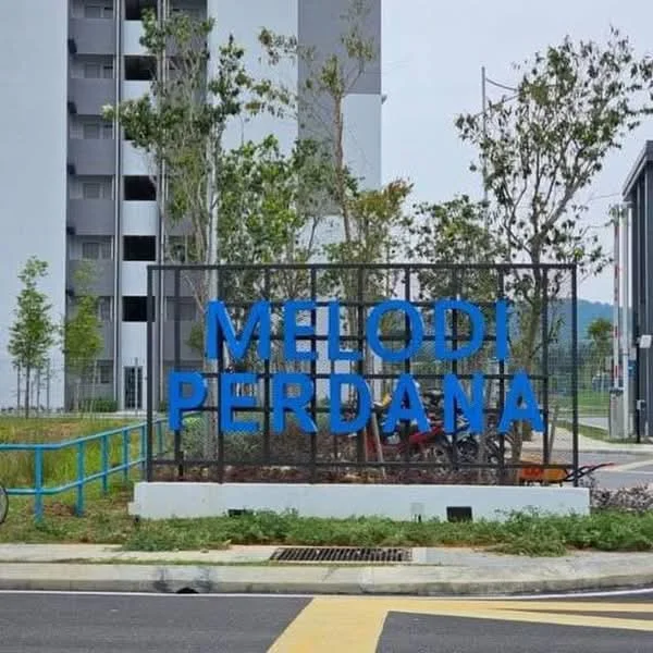 Exterior features: blue signage with the text 'MELODI PERDANA', landscaped area with small trees, paved pathway, surrounding greenery, modern architectural elements, parking area visible; style: modern.