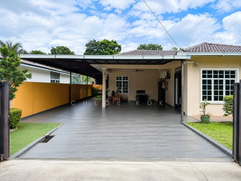 Exterior type: detached bungalow; features: covered car porch, grey tiled flooring, manicured lawn, garden area with shrubs, yellow painted wall, exterior wall with windows, air conditioning unit visible, outdoor seating area, paved driveway, gated entry; style: modern.