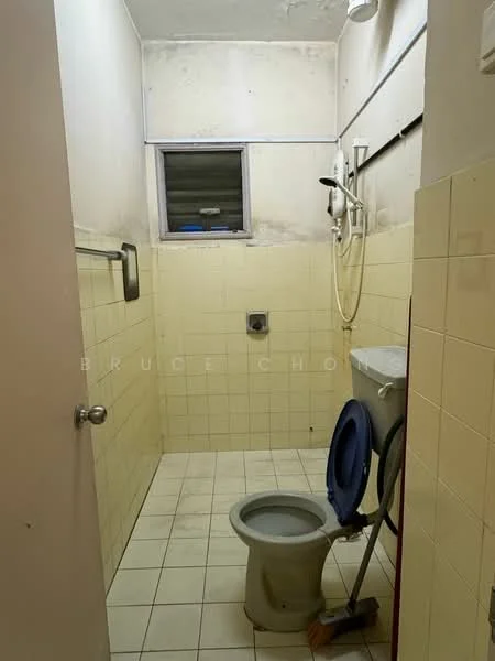 Bathroom features: white tiled walls, yellow tiled walls, white ceramic floor tiles, toilet, shower head, shower hose, window, towel rack, cleaning supplies, flush tank, wall-mounted mirror.