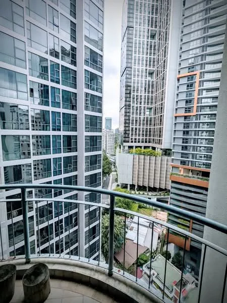 Room features: balcony with railing, city skyline view, surrounding high-rise buildings, glass facade buildings, greenery visible below, urban landscape; style: modern; view: city.