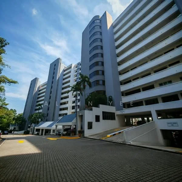 Exterior type: mid-rise condominium; features: grey painted facade, balconies on upper floors, landscaped entrance with palm trees, paved driveway, covered parking area, multiple storeys, large windows, security entrance, surrounded by greenery; style: modern.