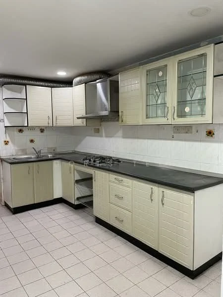 Kitchen features: L-shaped kitchen layout, light cream cabinetry with glass-front upper cabinets, black countertop, stainless-steel sink, chrome faucet, 4-burner gas hob, built-in stainless-steel range hood, white tiled backsplash, white tiled flooring, wall-mounted shelves, decorative wall tiles with floral pattern, under-cabinet lighting; style: modern.