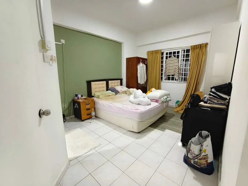 Bedroom features: queen-size bed with upholstered headboard, white bedding, wooden bedside table, table lamp, green accent wall, white painted walls, sliding window with sheer curtains, light brown wardrobe, tile flooring, clothes hanging on a rack, laundry basket, area rug; style: modern.