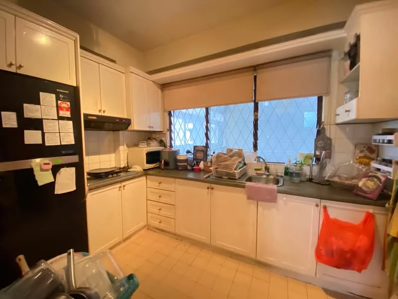 Kitchen features: white cabinetry, black countertop, stainless-steel fridge, built-in oven, gas hob, kitchen sink, window with grid pattern, beige tiled flooring, microwave, dishwasher, kitchen utensils, plastic storage bags, kitchen towels.