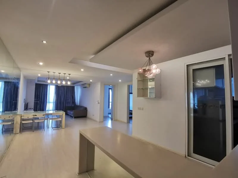 Living features: light wood flooring, white painted walls, recessed downlights, 5-blade ceiling fan with light, chandelier with multiple bulbs, large windows with sheer curtains, mirror wall, open-plan layout with dining area, sofa in neutral color, dining table with chairs; style: modern.