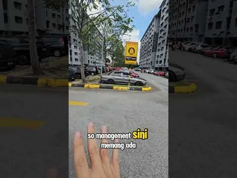 Exterior type: low-rise apartment block; features: multiple-storey building, parking lot with marked spaces, landscaped area with trees, signage visible, surrounding vehicles, asphalt road surface; style: modern.