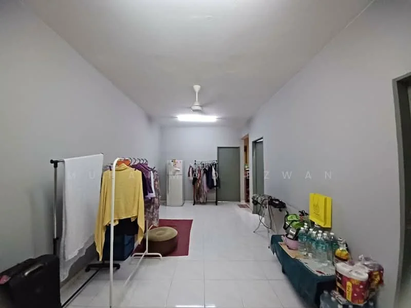 Room features: grey painted walls, white tiled flooring, ceiling fan, clothes rack, laundry drying rack, doorway to adjacent rooms, area rug, table with bottles, suitcase.