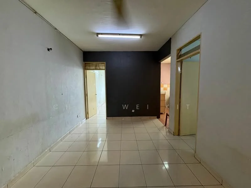 Room features: white painted walls, grey accent wall, glossy ceramic tile flooring, fluorescent ceiling light, doorway leading to another room, doorway leading to kitchen, empty space, no visible furniture.