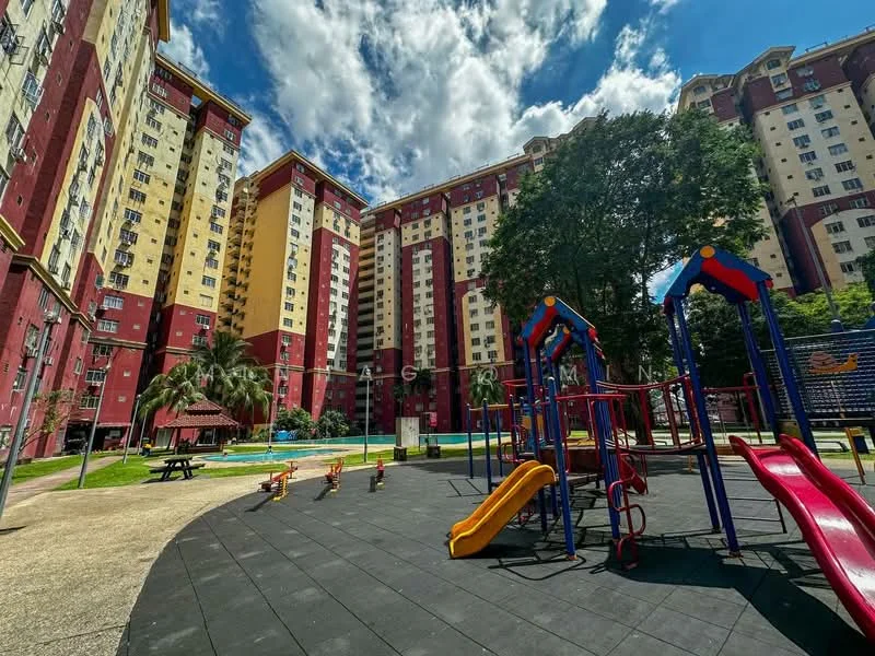 Exterior type: mid-rise condominium; features: playground with slides and climbing structures, swimming pool visible in background, manicured landscaping with palm trees, multi-storey building with red and yellow facade, covered gazebo, outdoor flooring, sunny weather with blue sky and clouds; style: modern.