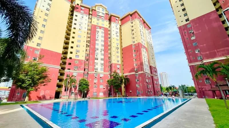 Exterior type: high-rise condominium; features: red and yellow painted facade, multiple storeys, swimming pool, surrounding palm trees, landscaped garden area, pool deck with loungers, balconies on upper floors, manicured lawn, parking area visible, urban context with nearby buildings; style: modern.