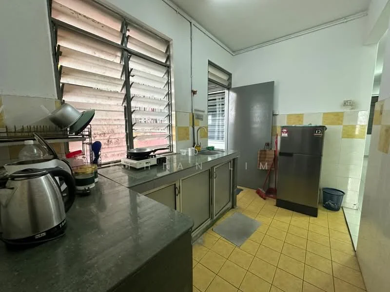 Kitchen features: green granite countertop, stainless-steel sink, chrome faucet, grey cabinetry, tile backsplash, kettle, stainless-steel fridge, window with horizontal slats, yellow ceramic tile flooring, wall-mounted shelves.