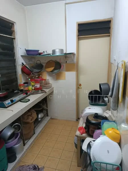 Kitchen features: white tiled walls, yellow tiled backsplash, laminate countertop, built-in cabinets, open shelving, stainless-steel gas stove, various cooking pots and pans, multiple plastic containers, floor tiles in beige, door leading to another room.