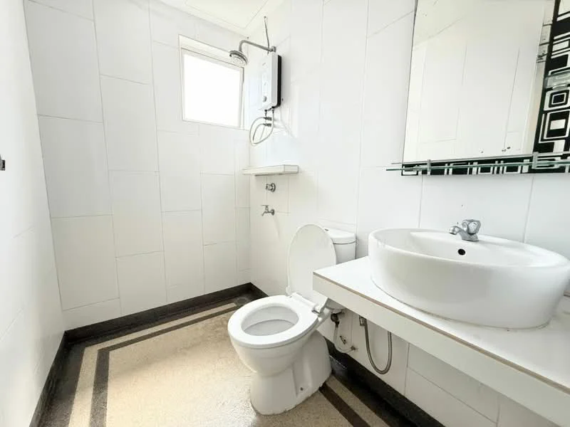 Bathroom features: white tiled walls, grey tiled flooring, round white sink, chrome faucet, one-piece toilet, mirror with decorative border, window for natural light, wall-mounted water heater, shelf above sink; style: modern.