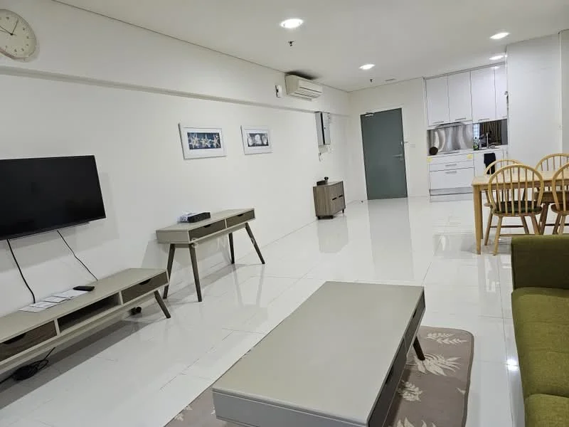 Living features: white painted walls, glossy tile flooring, 5-blade ceiling fan with light, wall-mounted TV, TV console, coffee table, area rug with floral pattern, green fabric sofa, dining table with wooden chairs, air conditioning unit, decorative wall art, clock on wall; style: modern. Kitchen features: white cabinetry, stainless-steel appliances, built-in oven, freestanding range oven, double-bowl stainless-steel sink, chrome pull-down faucet, white quartz countertop, tile backsplash; style: modern.
