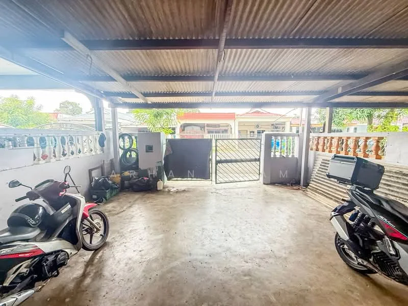 Exterior type: car porch; features: concrete flooring, metal roof, open-air structure, two parked motorcycles, gate at entrance, surrounded by walls, fenced area, natural light from outside; style: minimalist.