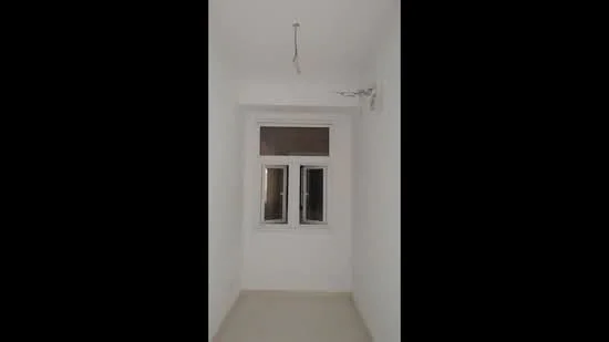 Room features: white painted walls, plain ceiling, single window, light fixture, neutral flooring; style: minimalist.