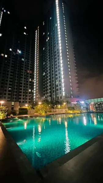 Exterior type: high-rise condominium; features: infinity pool, pool deck with loungers, landscaped garden, surrounded by greenery, illuminated building facade, glass curtain wall, night lighting, water features; style: modern.