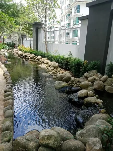 Exterior type: landscape garden; features: manicured garden, rock-lined water feature, small stream, boulders along the water, lush greenery, decorative plants, paved walkway, fenced perimeter; style: tropical-modern.