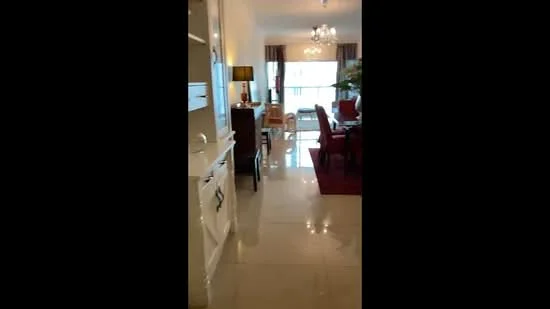 Room features: glossy tile flooring, white painted walls, chandelier, large windows with sheer curtains, dining table with chairs, sideboard cabinet, decorative plants, area rug, wall-mounted light fixture; style: contemporary.