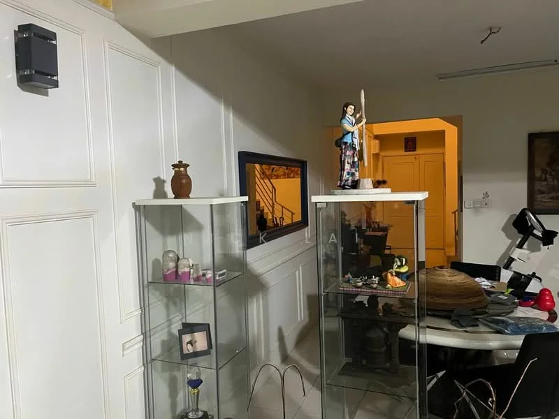 Room features: white painted walls, glass display cabinets, decorative figurine on display, table with various items, framed mirror, wooden flooring, ceiling light fixture, staircase visible in background; style: modern.