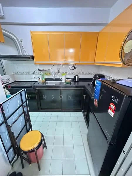 Kitchen features: orange high-gloss cabinetry, black countertop, single-bowl stainless-steel sink, chrome pull-down faucet, black fridge, built-in oven, ceramic tile flooring, exhaust hood, wall-mounted fan, white tiled backsplash, open shelving, kitchen utensils on countertop, small stool; style: modern.