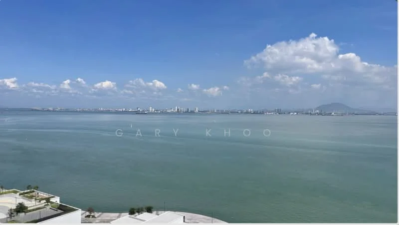 Exterior features: waterfront view, city skyline in background, clear blue sky, clouds, open water, distant mountains.
