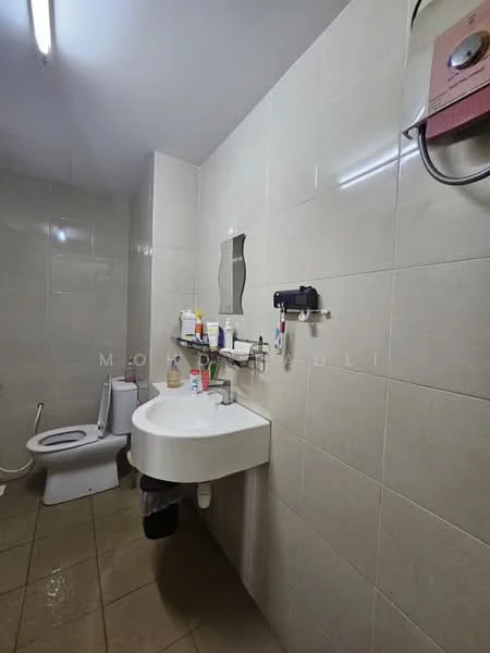 Bathroom features: white ceramic toilet, single-sink vanity with wall-mounted mirror, chrome basin mixer faucet, wall-mounted shower heater, light beige tiled walls, light brown tiled flooring, shelf with toiletries, towel rack.