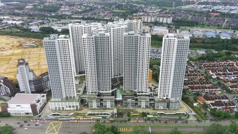 Exterior type: high-rise condominium; features: glass curtain wall, white painted facade, recessed balconies, multiple storeys, surrounded by greenery, adjacent to main road, parking area visible, landscaped grounds; style: modern.