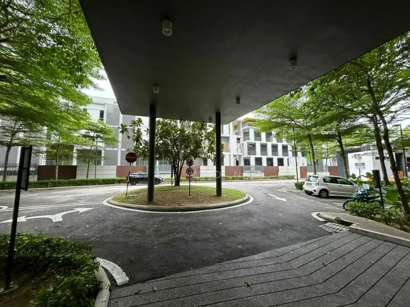 Exterior type: low-rise apartment block; features: covered entrance with overhang, landscaped greenery with trees, circular driveway, paved walkway, parking area visible, surrounding fencing, road signage, manicured lawn; style: modern.