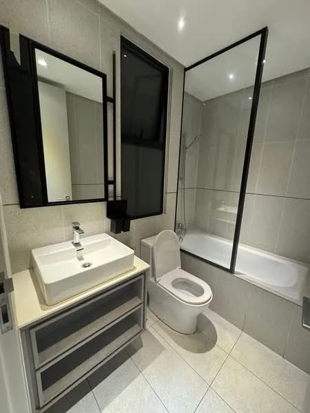 Bathroom features: white ceramic toilet, single-sink vanity with rectangular basin, chrome basin mixer faucet, framed mirror, glass shower enclosure, bathtub, grey tiled walls, light grey floor tiles, recessed downlights; style: modern.