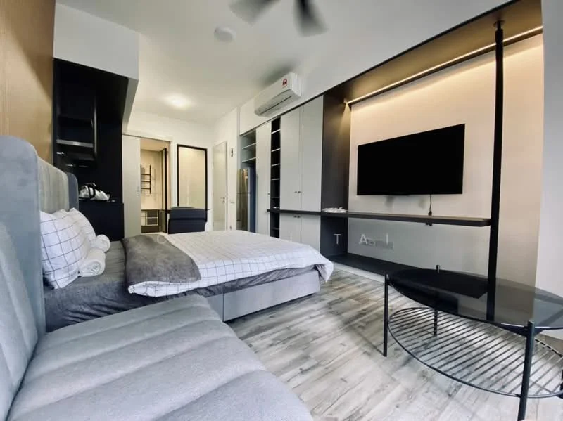 Room features: queen-size bed with grey bedding, sofa bed in grey fabric, black coffee table with metal frame, wall-mounted flat-screen TV, built-in cabinets with grey finish, recessed LED lighting, wooden flooring, air conditioning unit, desk and chair, kettle on countertop, open shelving, white walls; style: modern.