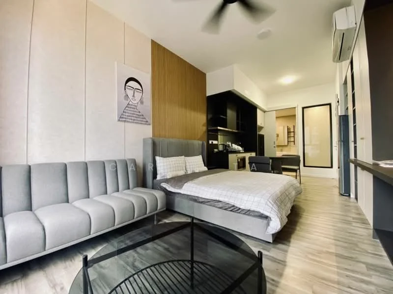 Living features: grey fabric sofa with tufted design, round glass coffee table, queen-size bed with grey bedding, wood accent wall, white painted walls, laminate flooring, ceiling fan, built-in kitchen with black cabinetry, refrigerator, microwave, kitchen countertop, sliding glass door, window with sheer curtains; style: modern.
