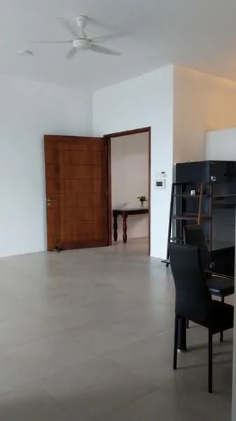 Room features: white painted walls, light-colored tile flooring, ceiling fan, wooden door, dark wood furniture, table with flower vase, black dining chair, open space layout; style: modern.