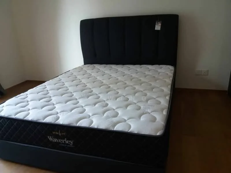 Bedroom features: black upholstered headboard, queen-size mattress, wooden flooring, white painted walls, bedside table, decorative tag on mattress; style: modern.