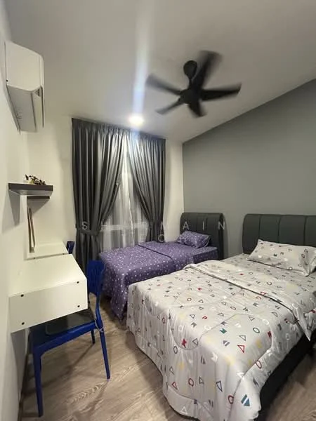 Bedroom features: two beds with patterned bedding, grey accent wall, white painted walls, wooden flooring, 5-blade ceiling fan, floor-to-ceiling window with sheer curtains, study desk with chair, decorative items on shelf; style: modern.