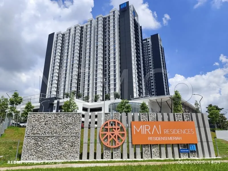 Exterior type: high-rise condominium; features: grey concrete facade, glass curtain wall, recessed balconies, landscaped entrance with stone cladding, signage with logo, manicured lawn, surrounded by greenery, multi-storey structure; style: modern.
