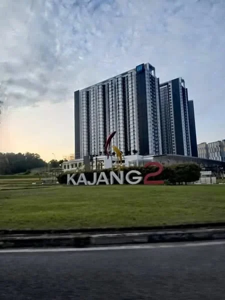 Exterior type: high-rise condominium; features: glass curtain wall, signage with 'KAJANG2', manicured lawn, surrounding greenery, multiple storeys, modern architectural design; style: modern.