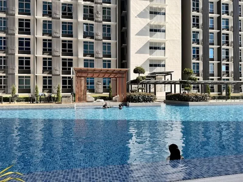 Exterior type: high-rise condominium; features: infinity pool, pool deck with loungers, landscaped garden, wooden pergola, seating area, mature trees, modern architecture, glass curtain wall, balconies on upper floors; style: modern.