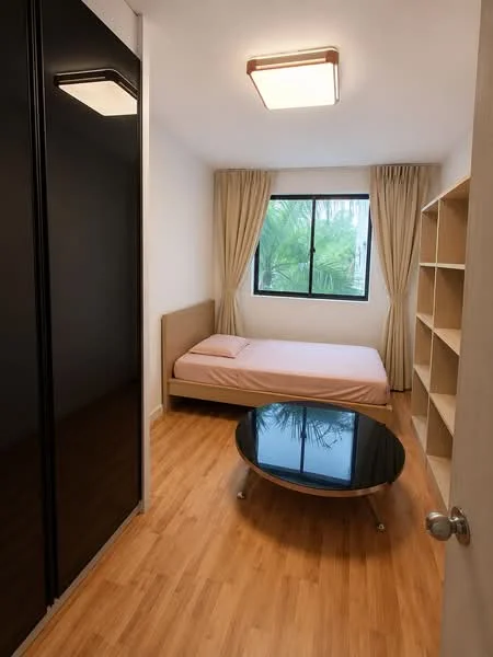 Bedroom features: queen-size bed with pink bedding, black sliding wardrobe, wooden flooring, large window with sheer curtains, round black coffee table, built-in shelving unit, ceiling light fixture; style: modern; view: garden.