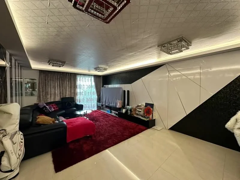 Living features: black leather sectional sofa, red throw blanket, area rug in red, white feature wall with geometric design, black accent wall, recessed LED lighting, chandelier with crystals, floor-to-ceiling curtains, TV console with decorative items, polished tile flooring; style: modern.