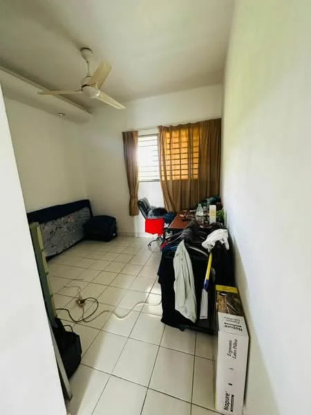Room features: white painted walls, white tiled flooring, ceiling fan, window with brown curtains, sofa bed, wooden desk, plastic chair, clothes on a rack, various items on the desk.