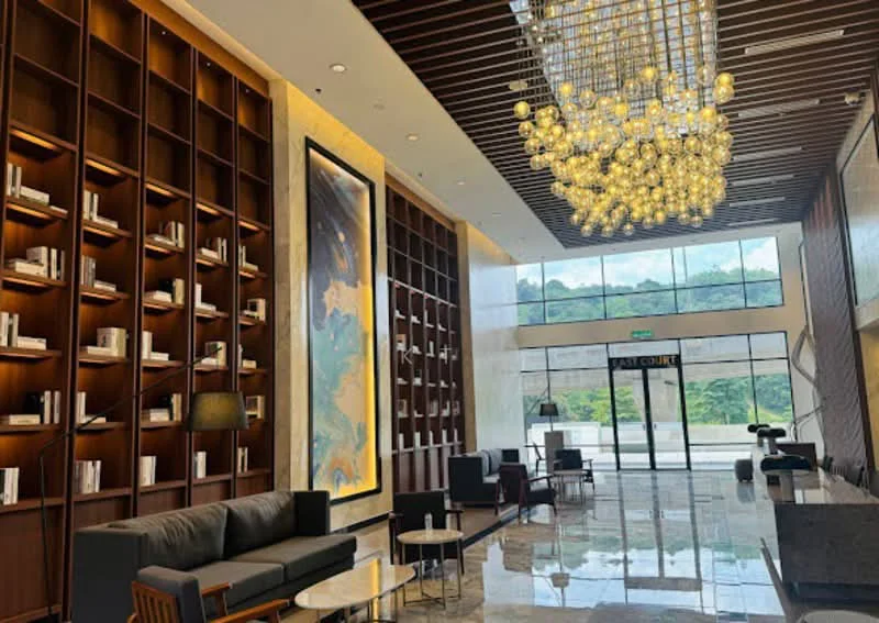 Living features: marble flooring, wooden feature wall with built-in shelves, large glass windows, chandelier with multiple bulbs, sofa in dark fabric, coffee table, armchairs, decorative artwork, floor lamp; style: modern; view: garden.