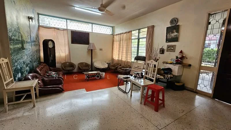 Living features: cream painted walls, exposed concrete flooring, 5-blade ceiling fan, large windows with natural light, brown leather sofas, wooden chairs, red plastic stool, decorative wall art, table lamp, wooden side table, area rug in orange, wall-mounted clock, decorative items on shelves; style: traditional.